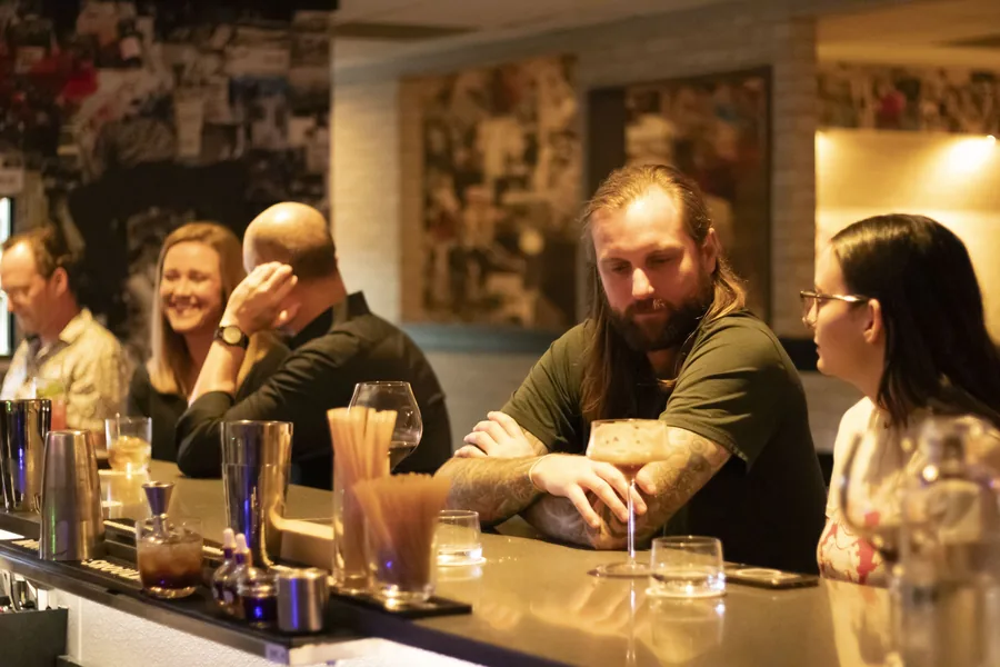 A full bar of guests talking over drinks